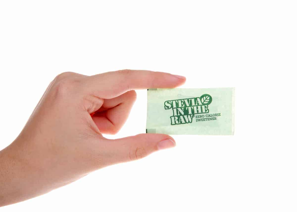 Womans hand holding Stevia packet