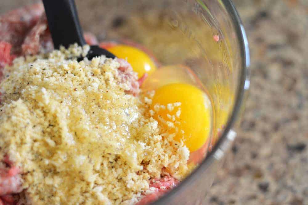Adding panko breadcrumbs and eggs to ground meat mixture