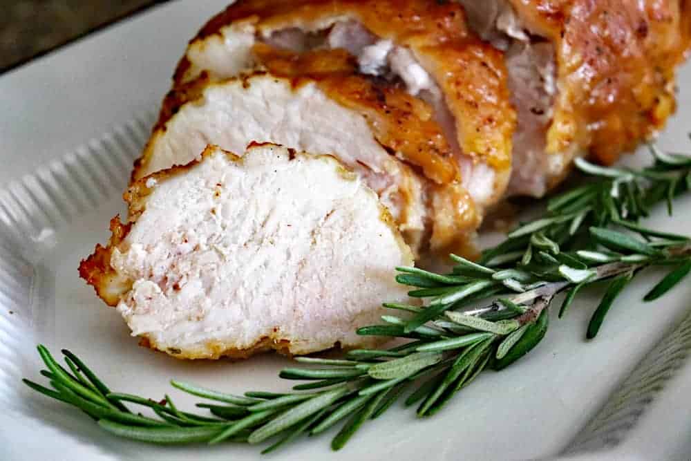 Sliced Herb Roasted Turkey Breast on a white platter