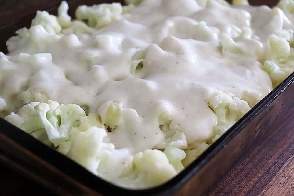 Add cheese sauce to top of Cheesy Cauliflower Gratin