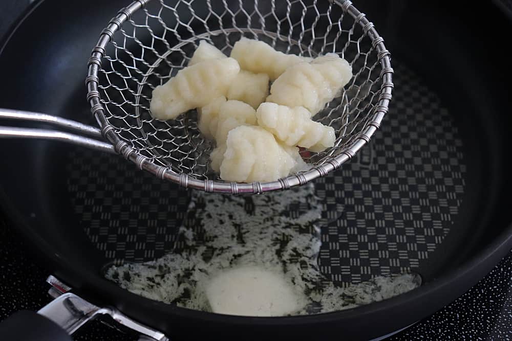 Adding boiled gnocchi to a saute pan with butter