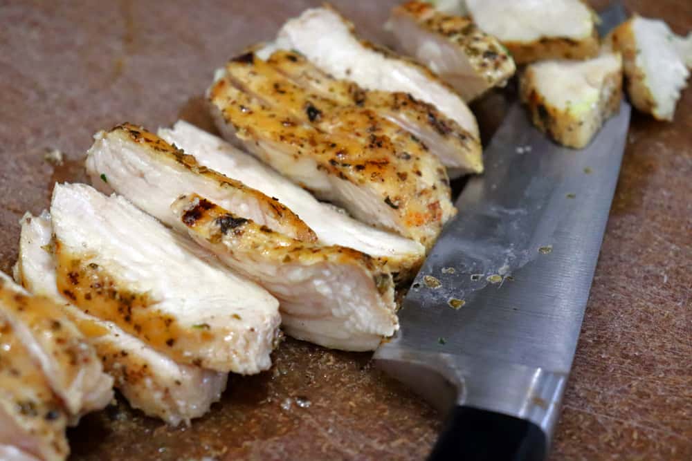 slicing the grilled chicken for Chicken and Broccoli Penne Alfredo