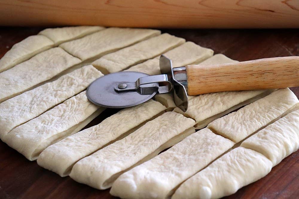 Cut the pizza dough into 16 strips
